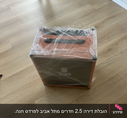 ארגז עטוף בניילון על רצפת עץ